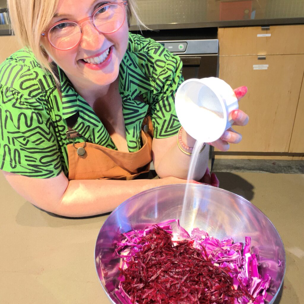 Associate Professor of Nutrition, Dr. Chelsie Falk prepares a bowl of beets and shredded cabbage, which will ferment over time into sauerkraut. Fermentation is a cooking technique she teaches as part of the Healing Foods Practicum in the NUNM Teaching Kitchen.