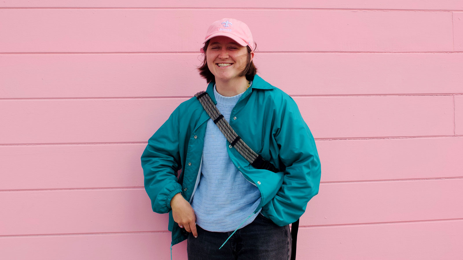 Lydia Norby-Adams standing in front of pink wall