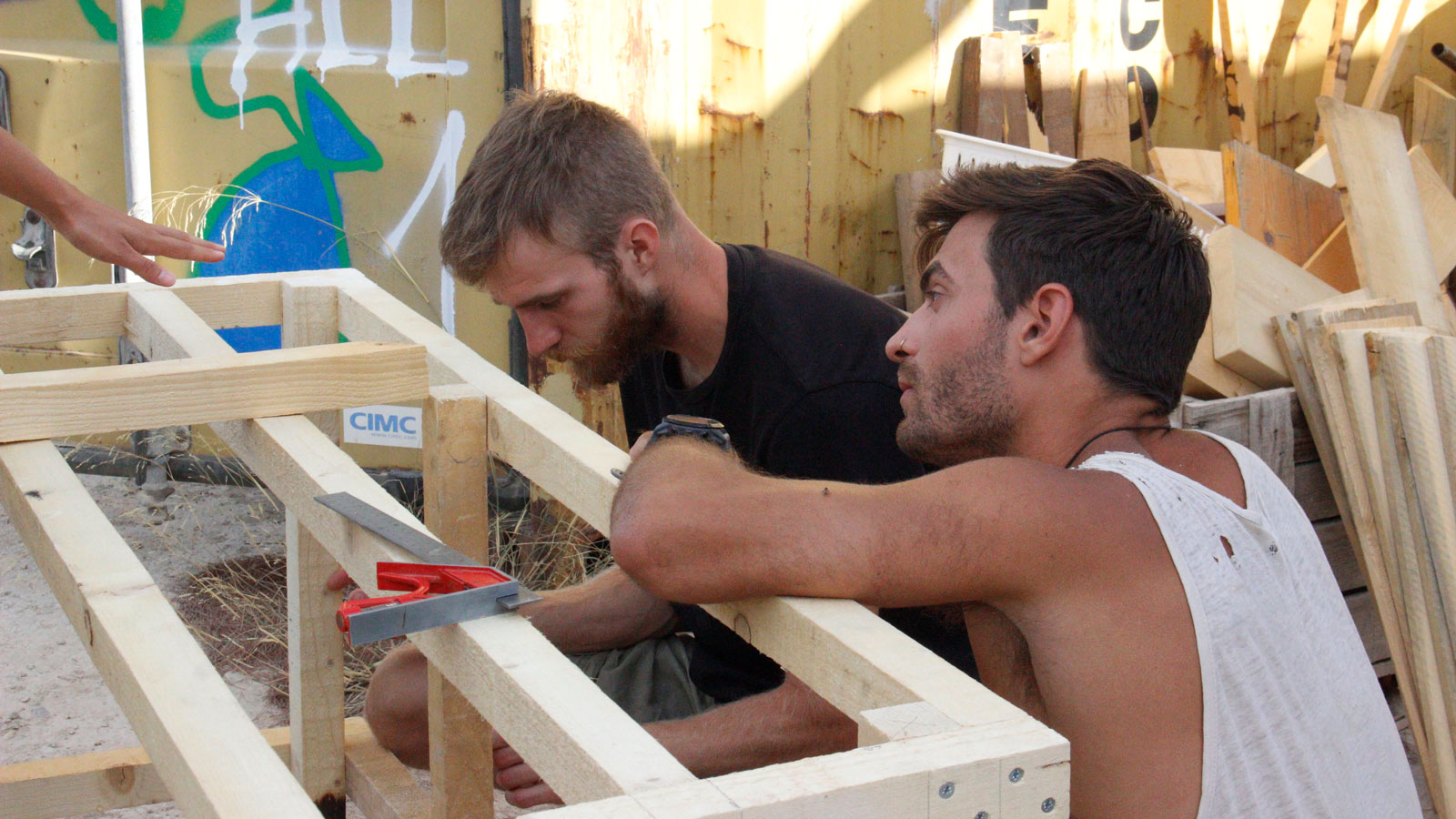 2 NUNM students building wooden structure in rural Greece