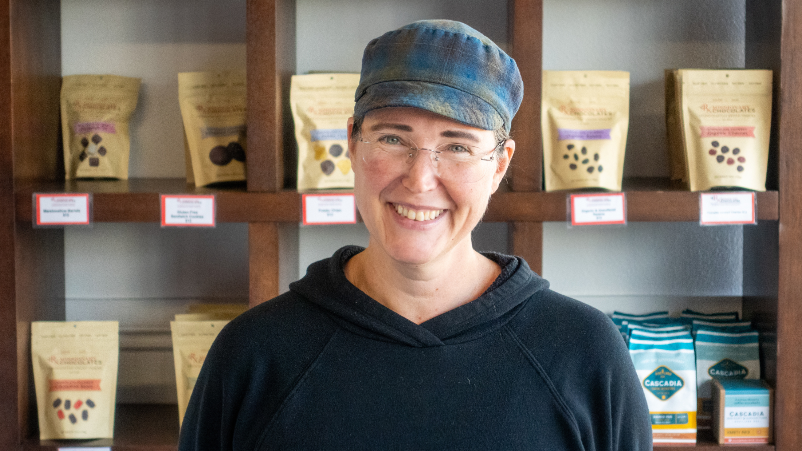 Dr. Berry at her store in front of shelf of chocolate products