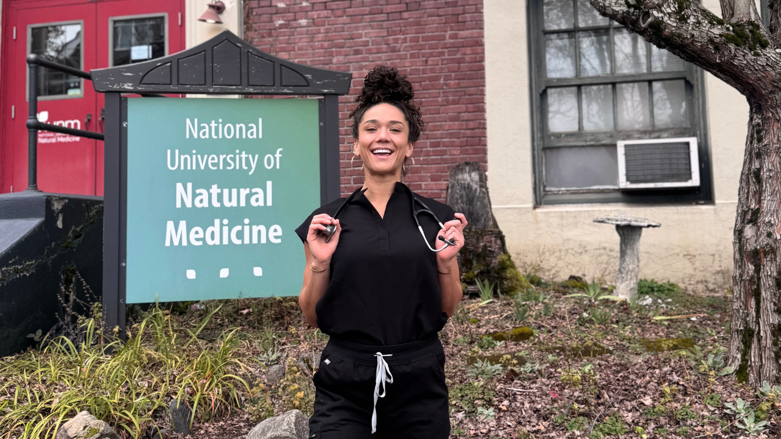 ND Student stands in scrubs outside NUNM