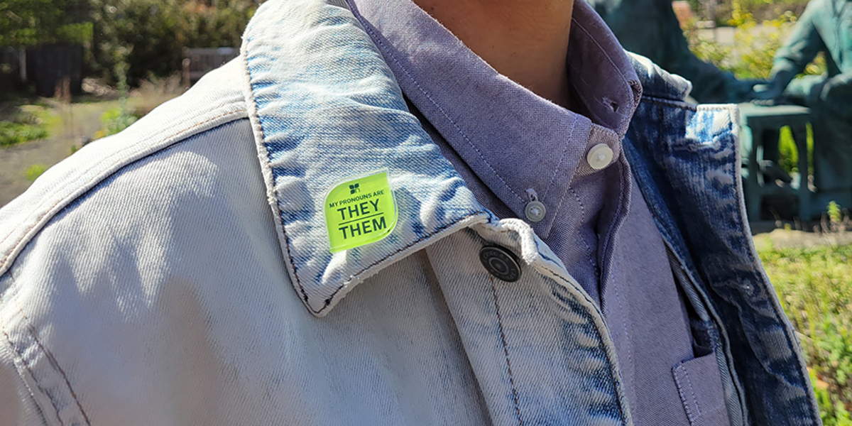 Ada Catanzarite (they/them) wears a pronoun pin. Ada is the Community Engagement and Patient Services Manager at NUNM, and also facilitates the LGBTQIA+ Affinity Group on campus.