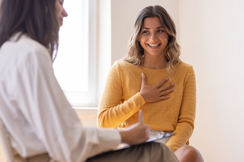 A patient smiles while speaking with their doctor of naturopathic medicine.