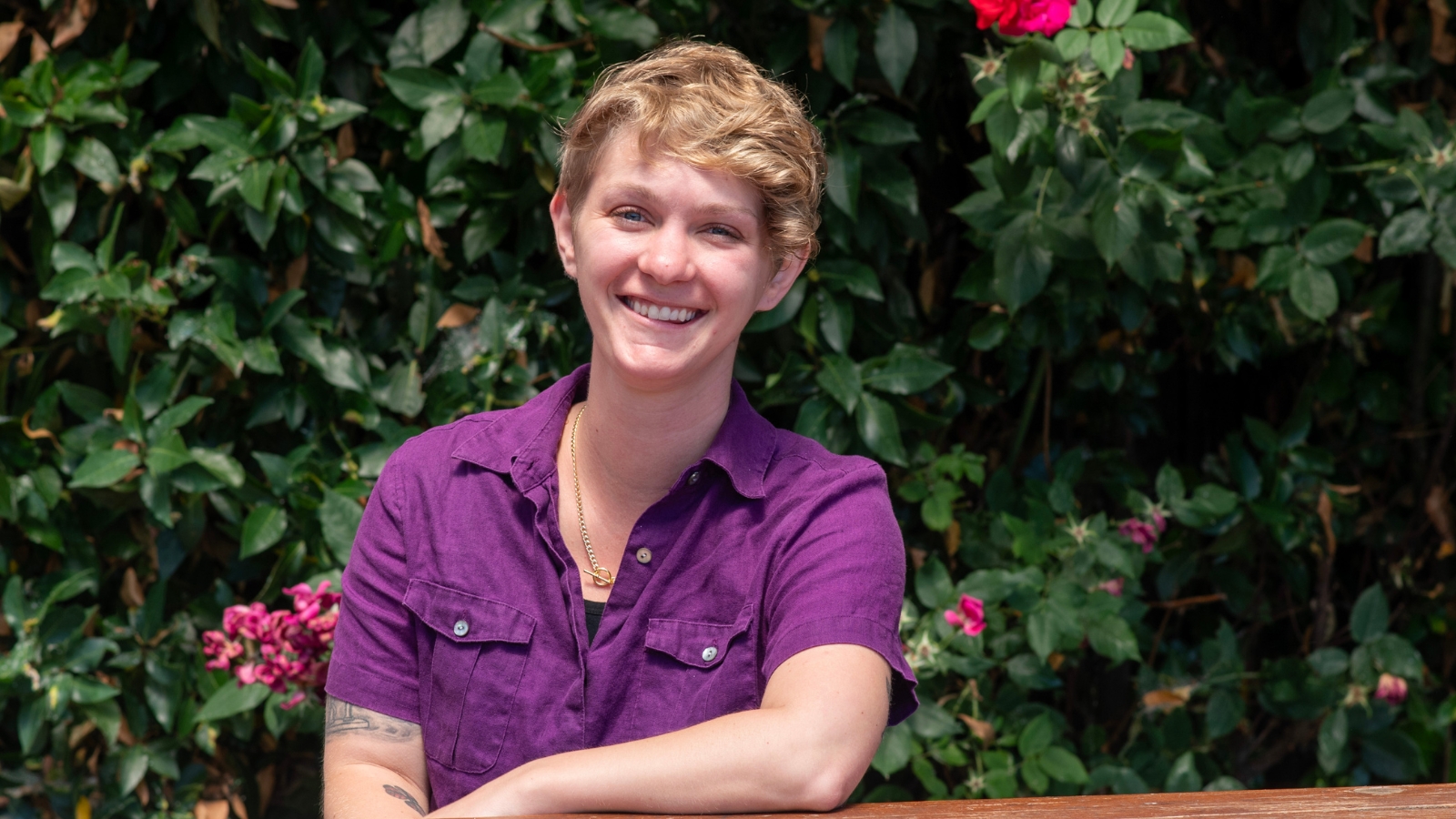 Nicole McGee, an NUNM admissions counselor smiling for a photo with greenery in the background