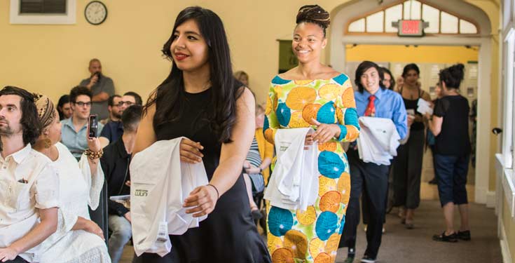 NUNM students walk while holding white coats during White Coat Ceremony