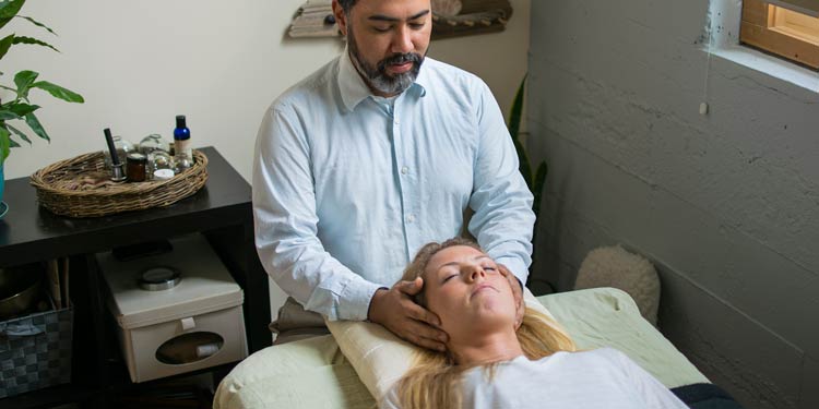 Acupuncturist holding patients head