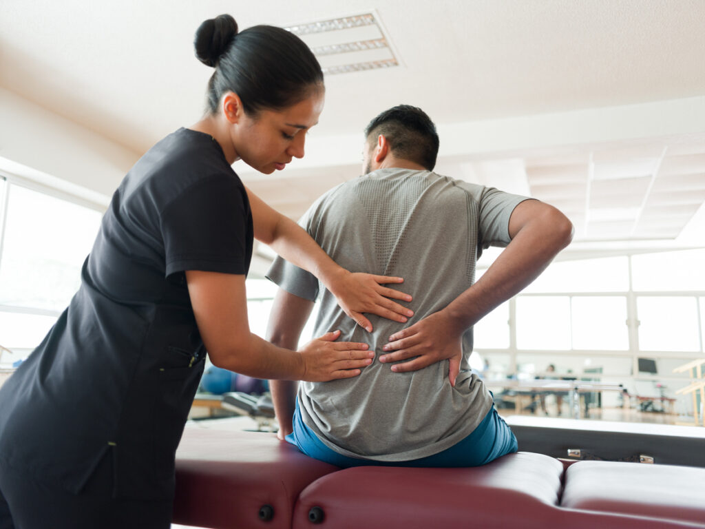 A massage therapy student applies their skills to a patient experiencing chronic pain.