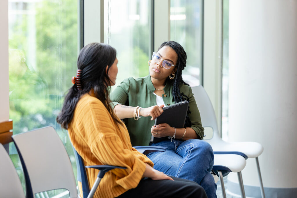 Two women discuss the admissions process.