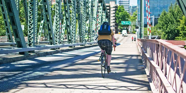 Person riding biking across bridge in Portland